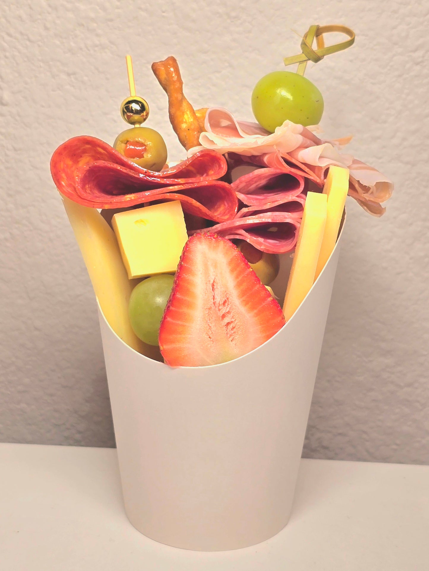 Cheeses, charcuterie and fruits in personal presentation.